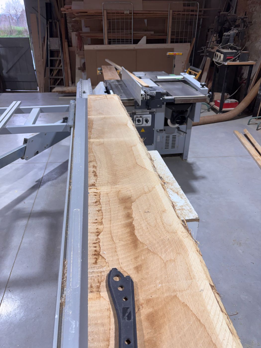 Dégauchissage d'une planche brute à l'atelier