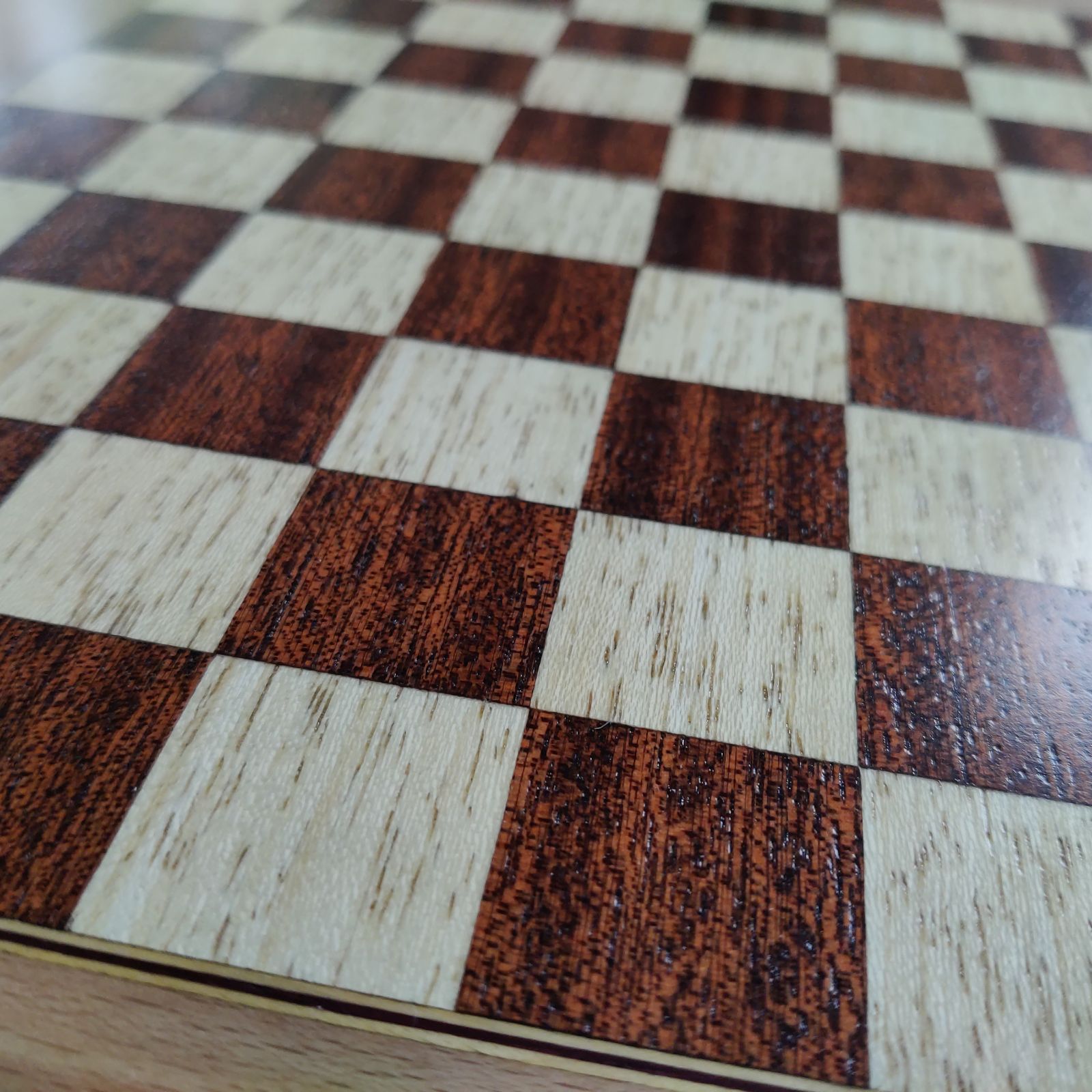 Damier en marqueterie — détail des cases en lumière rasante
